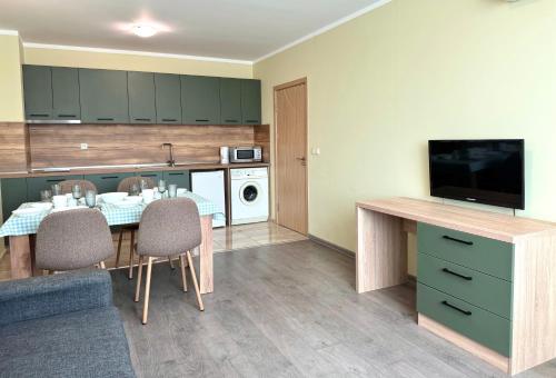 a kitchen with a table with chairs and a television at Evi Apartments 2 in Pomorie