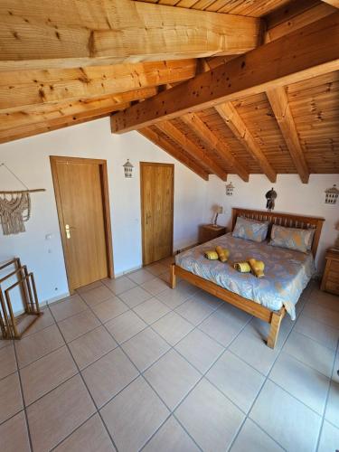a bedroom with a bed and a wooden ceiling at Casa Delbon Guest House in Aljezur