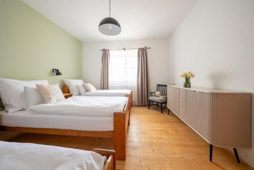 a bedroom with two beds and a dresser at penzion Dvorce in Třeboň