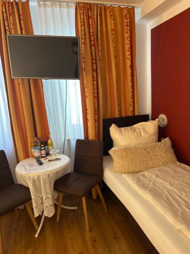 a bedroom with a bed and a table and chairs at Hotel Pension Haydn in Munich
