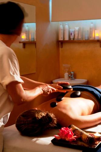 a woman getting a massage in a bath room at Saturnia Tuscany Country House in Saturnia