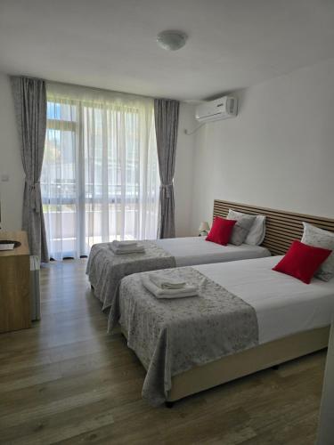 a bedroom with two beds and a large window at Casa Del Mar in Primorsko