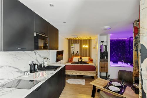 a kitchen and a bedroom with a bed at Love Room - Luxe et Romance in Bourg-en-Bresse