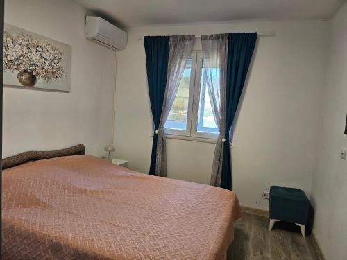 a bedroom with a bed and a window at Apartman Mano in Topla