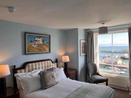 a bedroom with a bed and a large window at The Royal Harbour Hotel in Ramsgate