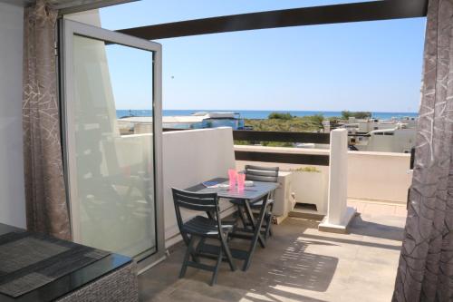 un patio avec une table et des chaises sur un balcon dans l'établissement Studio 74, Port Nature 2 au village naturiste, au Cap d'Agde