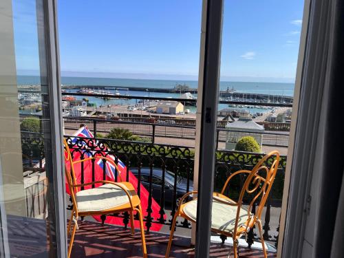 a balcony with two chairs and a view of the ocean at The Royal Harbour Hotel in Ramsgate