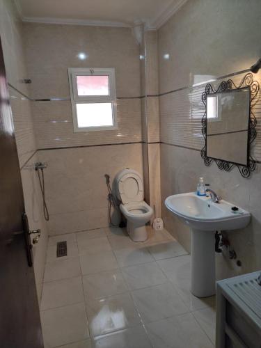 a bathroom with a toilet and a sink at Charming Apt Pool & Beach in Sidi Bouzid