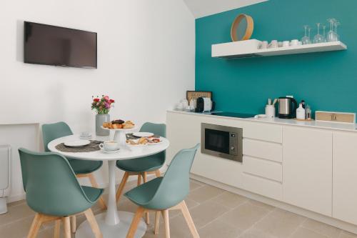 a kitchen with a table and chairs and a kitchen with blue walls at Santa Maria 24 in Monopoli