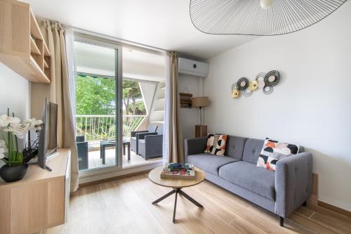 un salon avec un canapé bleu et une télévision dans l'établissement Le sable et pinède, à La Grande Motte