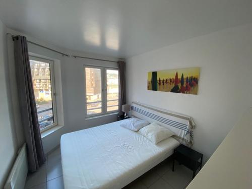 une chambre blanche avec un lit et deux fenêtres dans l'établissement Deauville Marina Cosy F3, bord de mer, terrasse exposée sud-ouest, à Deauville