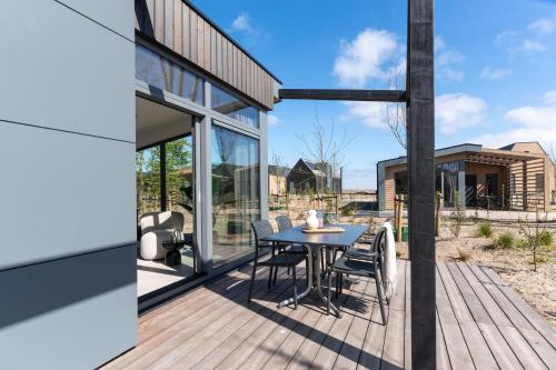 a wooden deck with a table and chairs on it at Enkhuizer Strand Chalet Suydersee Huys Nr 462 in Enkhuizen