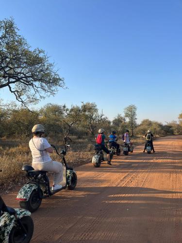 a group of people riding motorcycles down a dirt road at Lindiwe Safari Lodge in Hoedspruit