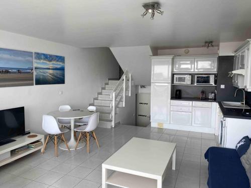 Il comprend un salon avec une table et une cuisine avec une salle à manger. dans l'établissement Deauville Marina Cosy F3, bord de mer, terrasse exposée sud-ouest, à Deauville