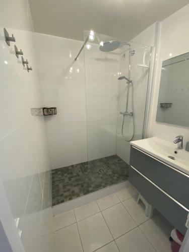 une salle de bain blanche avec une douche et un lavabo dans l'établissement Deauville Marina Cosy F3, bord de mer, terrasse exposée sud-ouest, à Deauville