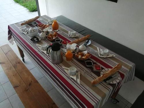 ein Tisch mit Essen und Getränken darauf in der Unterkunft Etxe goxoan chambres d'hôtes avec cuisine été équipée commune et jaccuzi in Itxassou