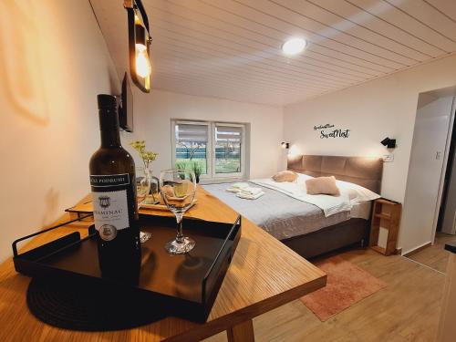 a bottle of wine on a table in a bedroom at Studio Spa Sweet Nest jacuzzi-sauna-bazen in Otočac