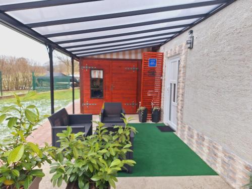 a patio with awning and a green floor at Studio Spa Sweet Nest jacuzzi-sauna-bazen in Otočac