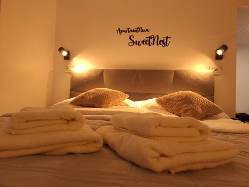 a bed with white towels on top of it at Studio Spa Sweet Nest jacuzzi-sauna-bazen in Otočac
