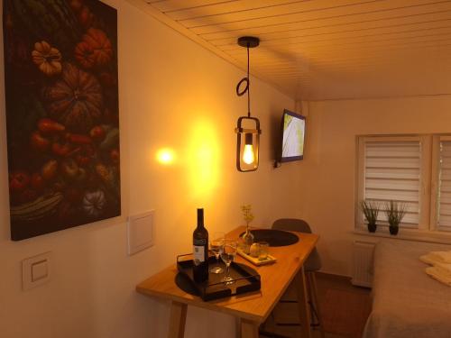 a room with a table with a bottle of wine and a painting at Studio Spa Sweet Nest jacuzzi-sauna-bazen in Otočac