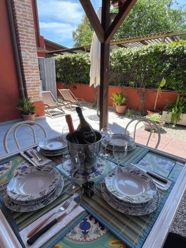 a table with plates and a bottle of wine on it at La casa di Barbara in Le Cerquete
