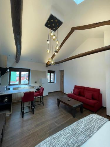 a living room with a red couch and a table at SEVIHOUSE Casa Vicente in Hospital de Órbigo