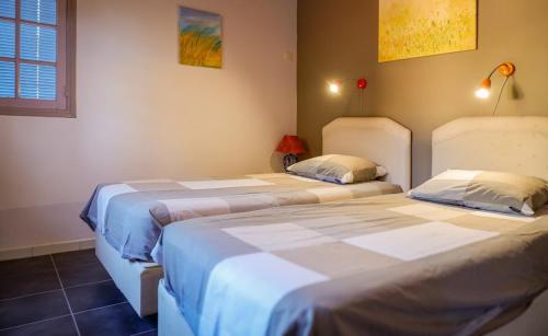 deux lits côte à côte dans une pièce dans l'établissement Villa des Chênes, à Roquebrune-sur Argens