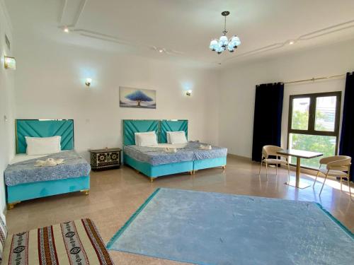 a bedroom with two beds and a table at Arabian Nights Nook in Muscat