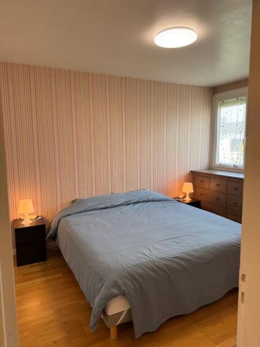 une chambre avec un lit et deux tables de nuit avec lampes dans l'établissement appartement périurbain de Paris et Versailles, à Les Clayes-sous-Bois