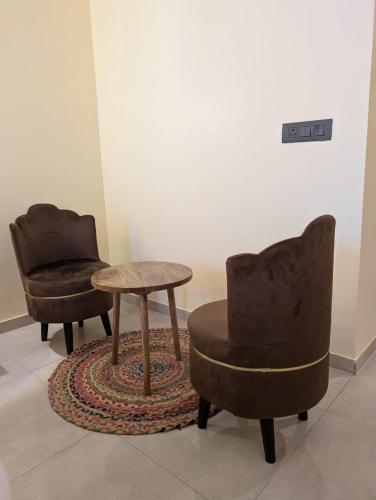 two chairs and a table in a room at Omaxe Hazratganj- Healing Staytion- Lucknow in Lucknow