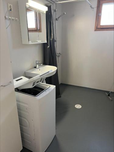 a white bathroom with a sink and a mirror at Ensitaival for 2 persons in Kajaani
