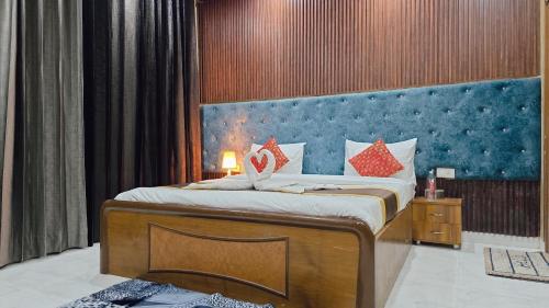 ein Schlafzimmer mit einem großen Bett mit blauem Kopfteil in der Unterkunft VilleFortune 3BHK Cottage In Nainital in Bhīm Tāl