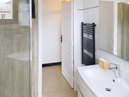 une salle de bain blanche avec un lavabo et une douche dans l'établissement bel appartement deux pas des plages 351L, à Cannes