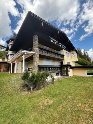 a building with a black roof and a grass field at Häusl am Roan Reutte Höfen in Hofen