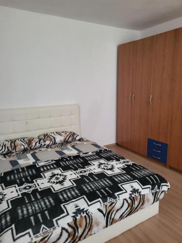 a bedroom with a bed with a black and white blanket at APARTMAJI Lea in Semedela