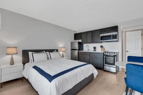 a bedroom with a large bed and a kitchen at Next to Beach & Boardwalk in Seaside Heights