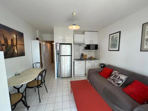 un salon avec un canapé et une table et une cuisine dans l'établissement Lanc, à Valras-Plage