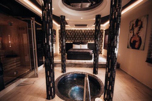 a master bathroom with a tub and a bed at Motel Delphin in Pristina