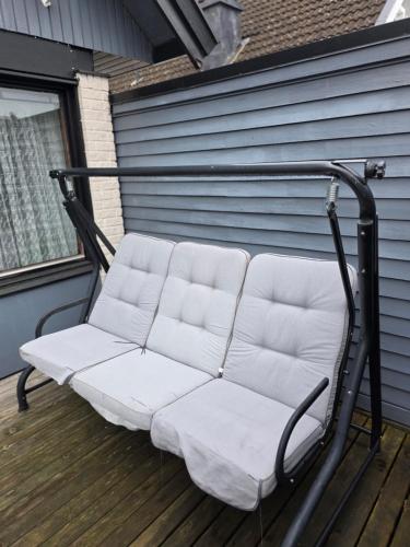 a white couch sitting on a deck at Lugn & Ro på Vändstigen in Nybro