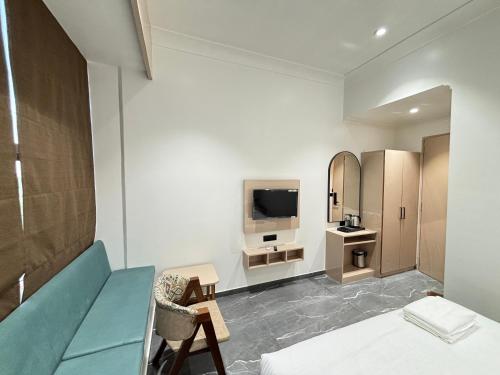 a bedroom with a couch and a tv in a room at Hotel The Octave in Surat