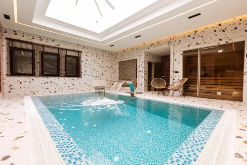 a swimming pool in a house with a ceiling at Motel Delphin in Pristina