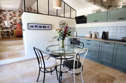 une salle à manger avec une table en verre et des chaises dans une cuisine dans l'établissement La Casa Mi A, à Rasteau