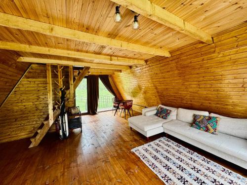 a living room with a white couch and wooden walls at Cottages in Chirdili in Chirdili