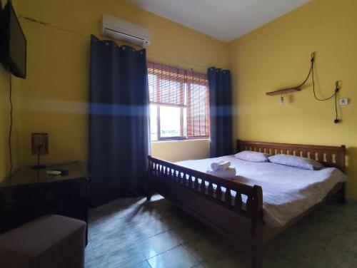 a bedroom with a bed with blue curtains and a window at Hostel Albania LoFT in Tirana