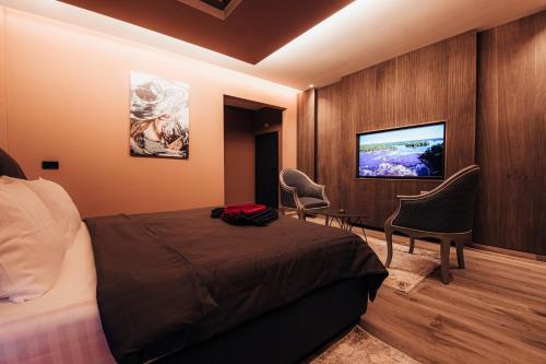 a hotel room with a bed and a flat screen tv at Motel Delphin in Pristina
