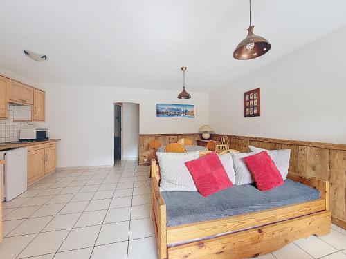 une chambre avec un lit en bois avec des oreillers rouges et blancs dans l'établissement Etoile Filante n2, à Morzine