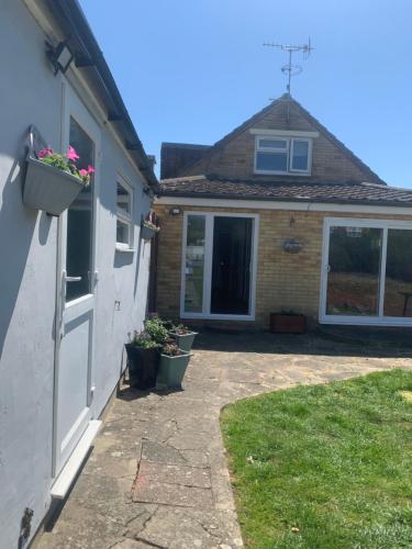 a house with potted plants on the side of it at The Haven garden room in Preston