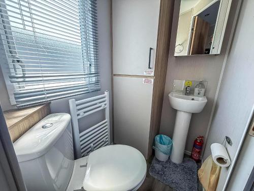 a small bathroom with a toilet and a sink at Stunning 6 Berth Caravan At Suffolk Sands Holiday Park Ref 45031G in Felixstowe