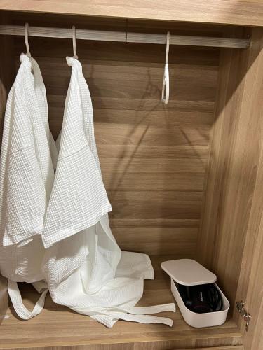 a closet with white towels hanging on a shelf at แพในฝัน รีสอร์ท in Ban Tha Thong Mon