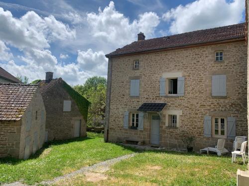 ein altes Backsteinhaus mit einem Hof davor in der Unterkunft Gite Chez Charles in Bersac-sur-Rivalier